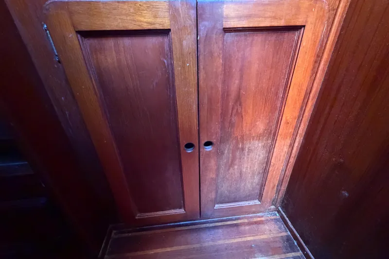 Slide: The Image of Wooden cabinet doors inside a 1983 Morgan Catilina boat, showcasing rich, polished wood grain. - 114