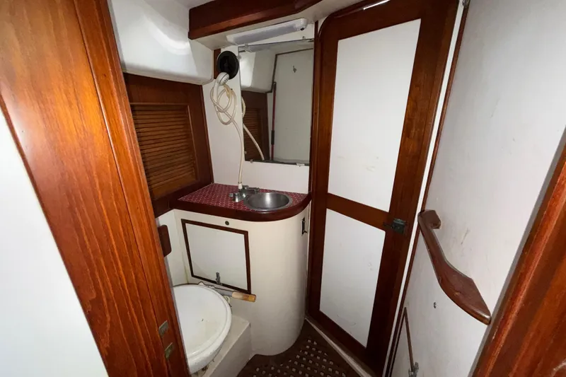 Slide: The Image of 1983 Morgan Catilina boat bathroom with wooden accents and compact sink area. - 120