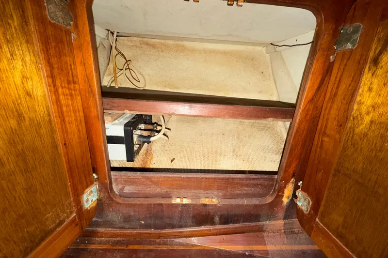 Slide: The Image of 1983 Morgan Catilina interior storage compartment with wooden finish and electrical components. - 128
