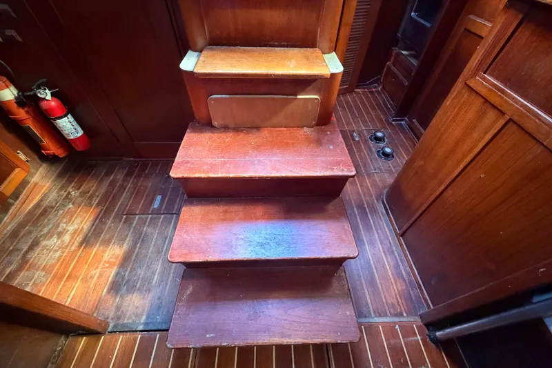 Slide: The Image of Wooden interior stairs of a 1983 Morgan Catilina boat, featuring rich wood tones. - 129