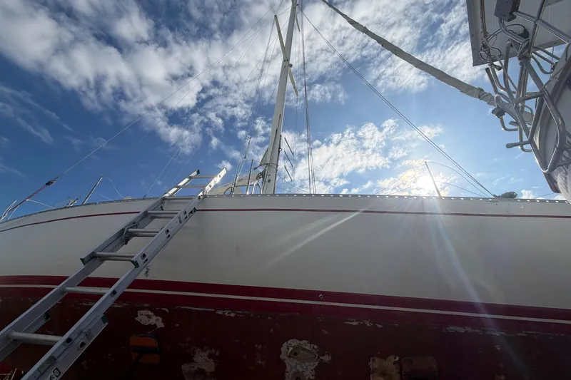 Slide: The Image of 1983 Morgan Catilina sailboat with ladder, under a bright blue sky. - 13
