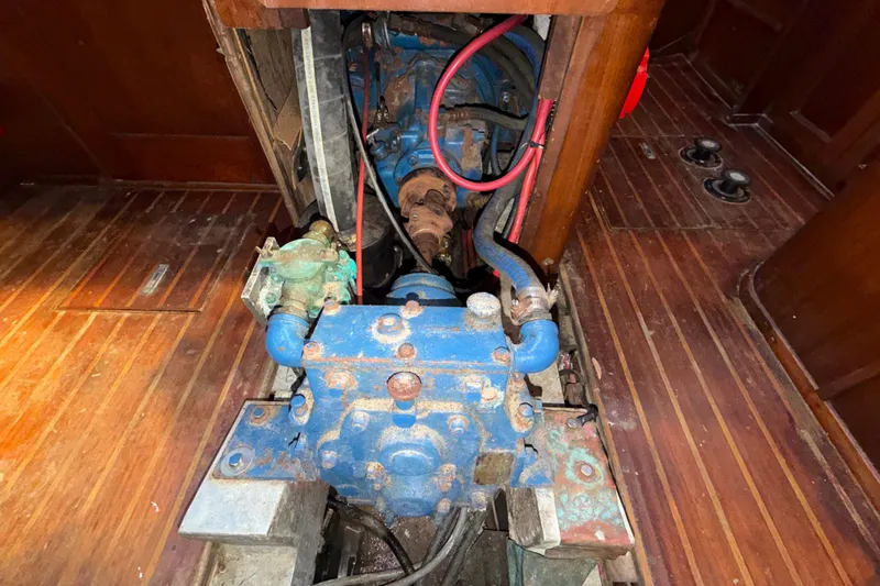 Slide: The Image of Engine compartment of a 1983 Morgan Catilina with visible blue machinery and wooden flooring. - 131