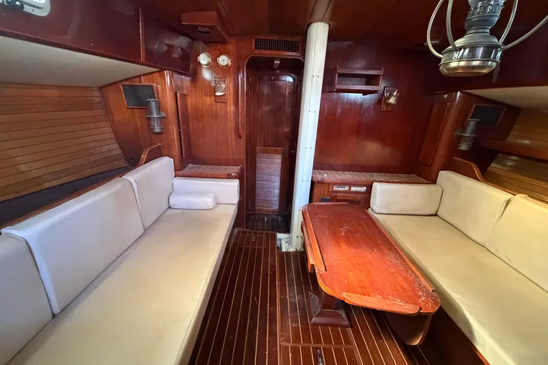 Slide: The Image of 1983 Morgan Catilina yacht interior with wooden furnishings and white cushioned seating. - 133