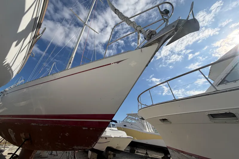Slide: The Image of 1983 Morgan Catilina sailboat on land, surrounded by other boats under a blue sky. - 14