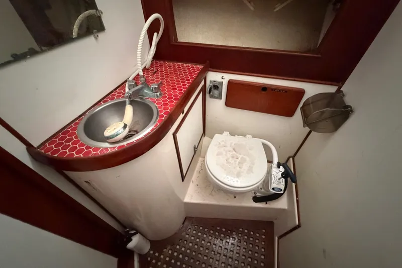 Slide: The Image of Compact 1983 Morgan Catilina boat bathroom with red-tiled sink and marine toilet. - 146