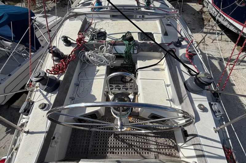 Slide: The Image of 1983 Morgan Catilina sailboat cockpit with steering wheel, ropes, and winches. - 18