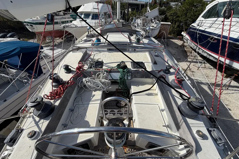 Slide: The Image of 1983 Morgan Catilina sailboat deck with ropes and winches in a marina setting. - 19