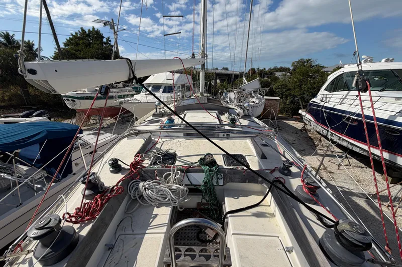 Slide: The Image of 1983 Morgan Catilina sailboat on land, surrounded by other boats under a partly cloudy sky. - 20