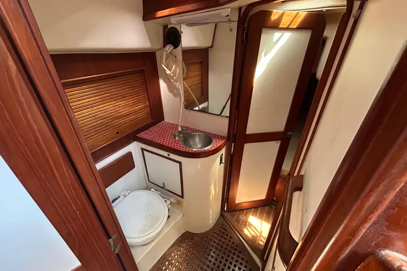 Slide: The Image of 1983 Morgan 45 Catalina yacht bathroom with wooden accents and compact design. - 206