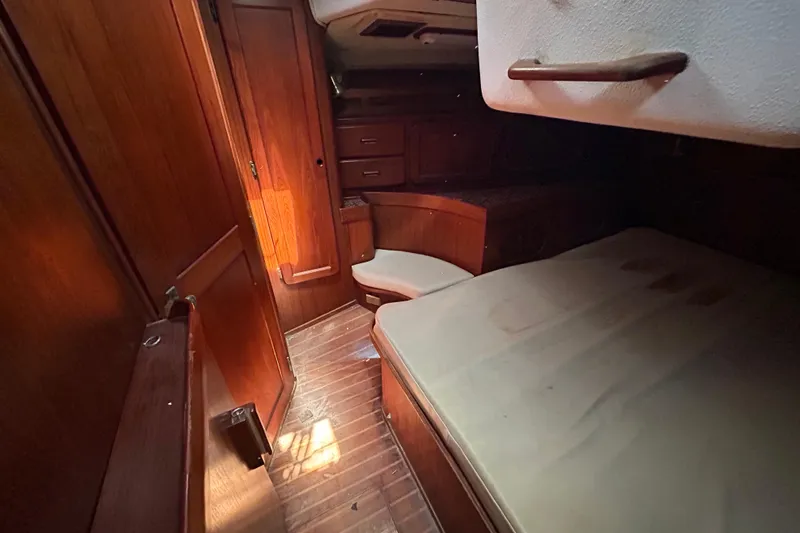 Slide: The Image of 1983 Morgan 45 Catalina yacht interior with wooden cabinetry and cozy sleeping area. - 207