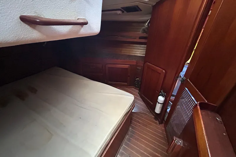 Slide: The Image of Interior cabin of 1983 Morgan 45 Catalina sailboat with wooden finishes and a mattress. - 208