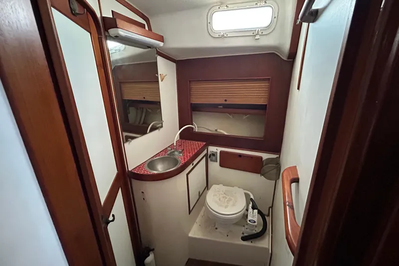 Slide: The Image of 1983 Morgan 45 Catalina yacht bathroom with sink, toilet, and wooden accents. - 209