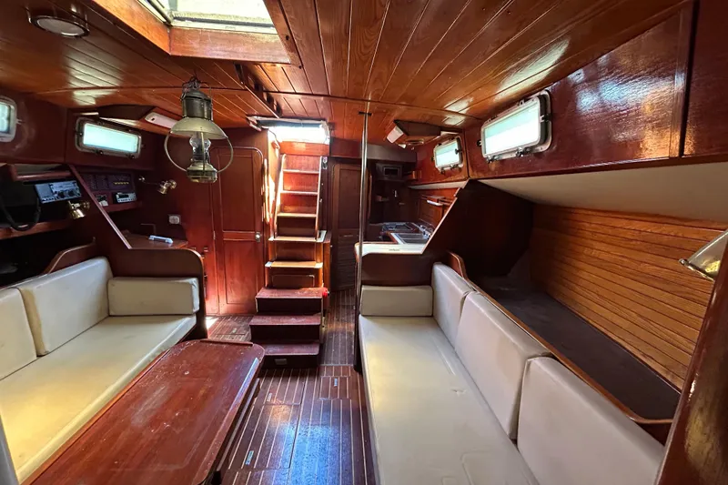 Slide: The Image of 1983 Morgan 45 Catalina yacht interior with wooden finish and cozy seating area. - 210