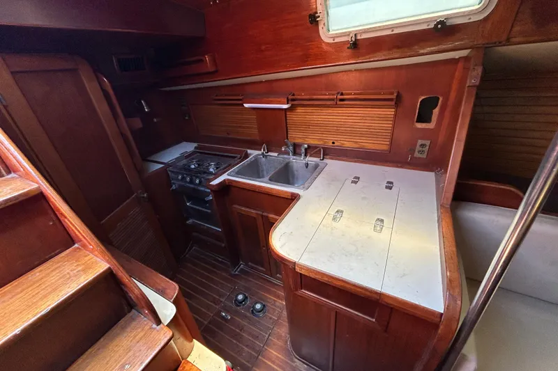 Slide: The Image of 1983 Morgan 45 Catalina yacht interior kitchen with wooden cabinetry and dual sinks. - 213