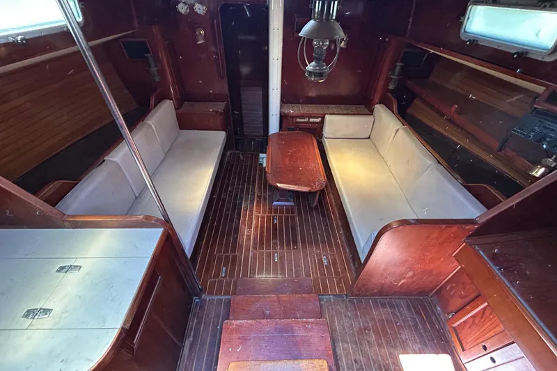 Slide: The Image of Interior of 1983 Morgan 45 Catalina sailboat with wooden furnishings and cozy seating area. - 214