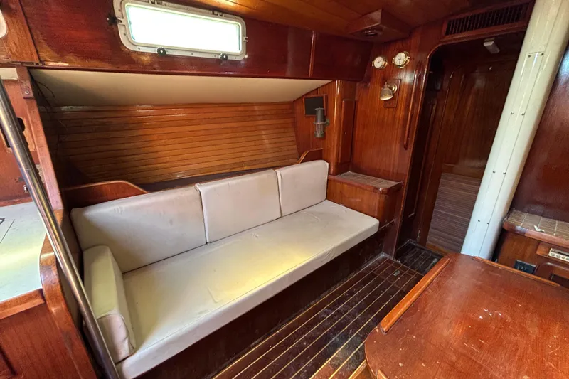 Slide: The Image of Interior of 1983 Morgan 45 Catalina sailboat with wooden paneling and cushioned seating. - 217