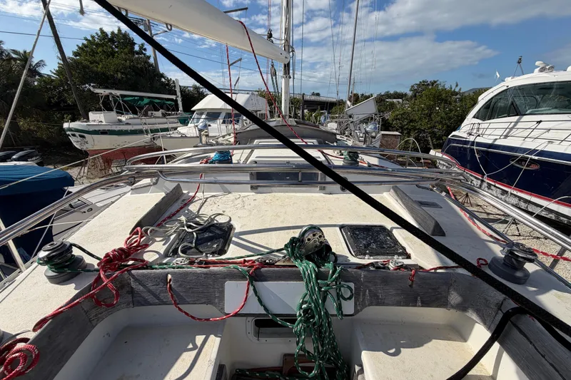 Slide: The Image of 1983 Morgan Catilina sailboat deck with ropes and winches, docked among other boats. - 28