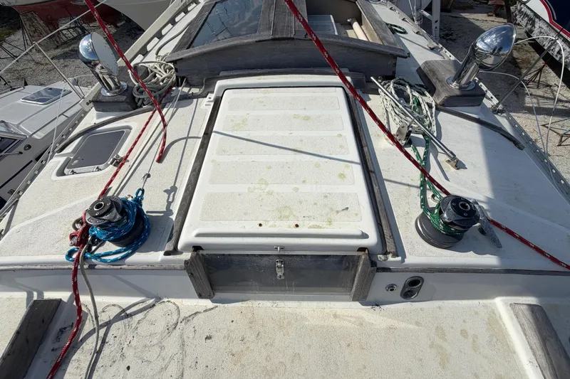 Slide: The Image of 1983 Morgan Catilina sailboat deck with winches, ropes, and hatch. - 31