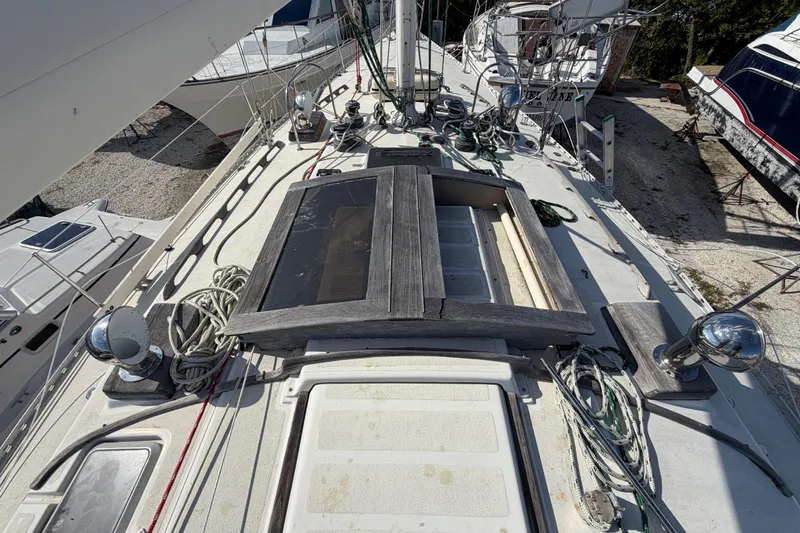 Slide: The Image of 1983 Morgan Catilina sailboat deck with ropes and equipment, docked among other boats. - 32