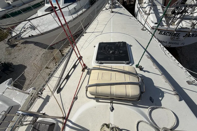 Slide: The Image of 1983 Morgan Catilina sailboat deck with hatch and rigging, docked among other boats. - 35