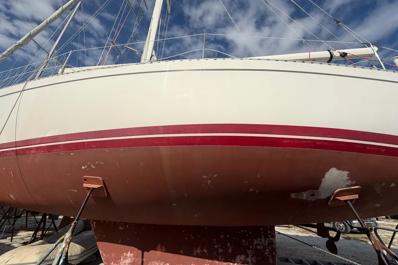 Slide: The Image of 1983 Morgan Catilina sailboat on dry dock, showing hull and keel under blue sky. - 4