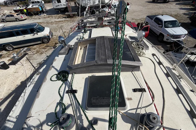 Slide: The Image of 1983 Morgan Catilina sailboat deck with ropes and hatches, surrounded by vehicles and boats. - 47