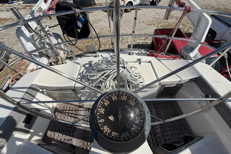 Slide: The Image of 1983 Morgan Catilina sailboat cockpit with compass, ropes, and steering wheel. - 59