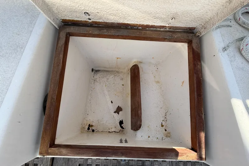 Slide: The Image of Open storage compartment on 1983 Morgan Catilina boat, featuring wooden frame and white interior. - 69
