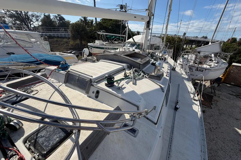 Slide: The Image of 1983 Morgan Catilina sailboat deck with winches and ropes, docked in a marina. - 71