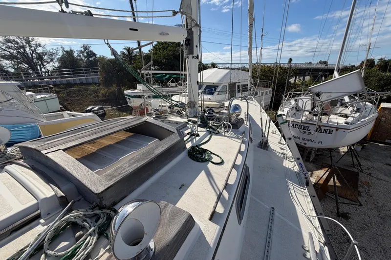 Slide: The Image of 1983 Morgan Catilina sailboat on land, surrounded by other boats, under a clear blue sky. - 72