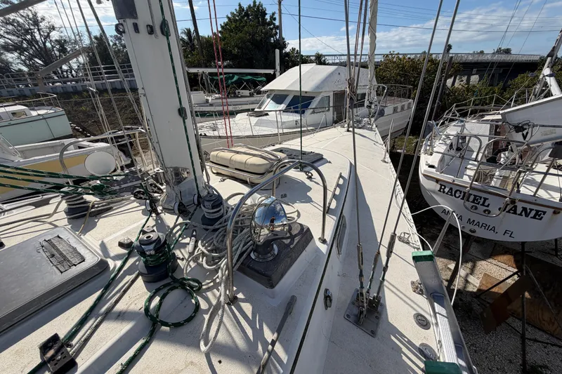 Slide: The Image of 1983 Morgan Catilina sailboat deck with rigging and nearby boats in a marina. - 73