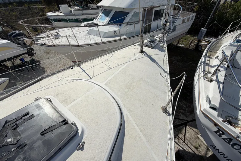 Slide: The Image of 1983 Morgan Catilina sailboat deck with surrounding boats in a marina setting. - 74