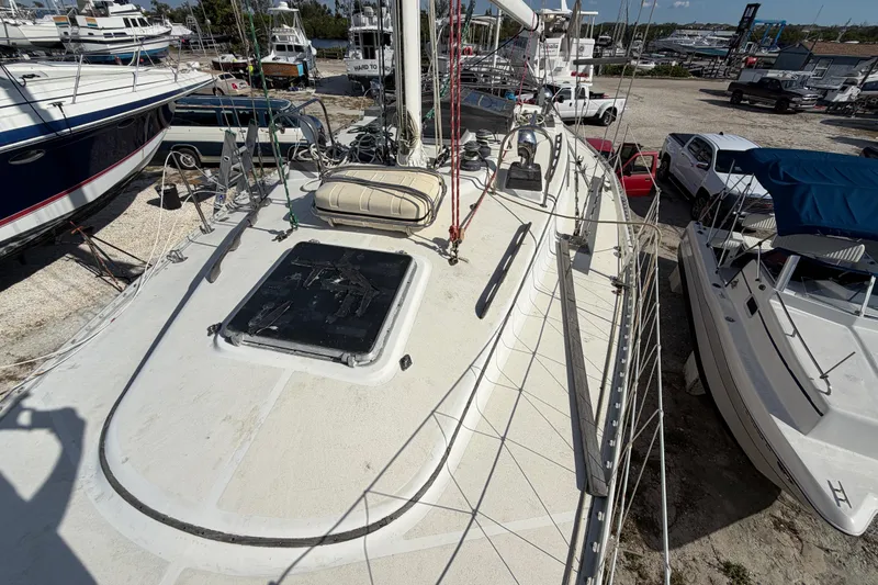 Slide: The Image of 1983 Morgan Catilina sailboat on dry dock, surrounded by other boats and vehicles. - 75