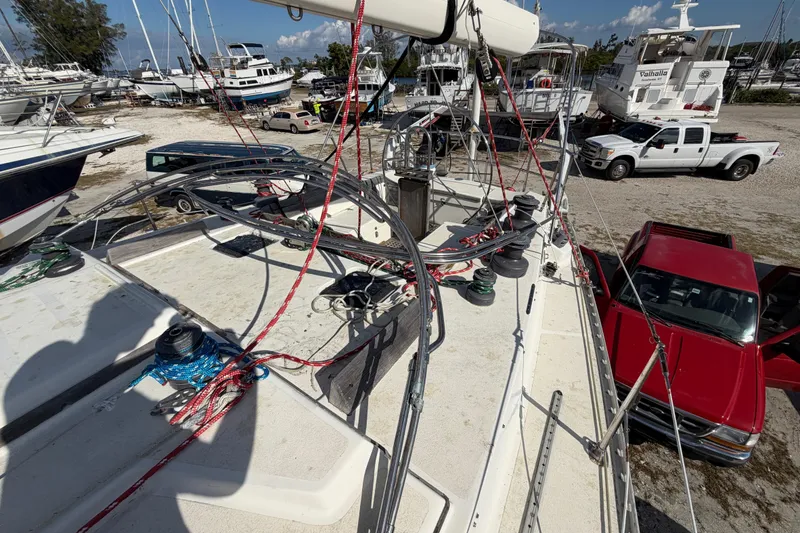 Slide: The Image of Deck view of 1983 Morgan Catilina sailboat with ropes, parked near trucks and other boats. - 78
