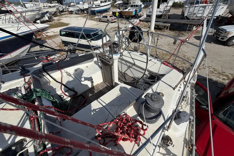 Slide: The Image of Cockpit of 1983 Morgan Catilina sailboat with ropes and winches, surrounded by parked boats. - 79