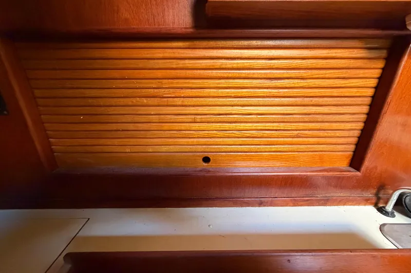 Slide: The Image of Wooden interior paneling of a 1983 Morgan Catilina boat, featuring a louvered design. - 92