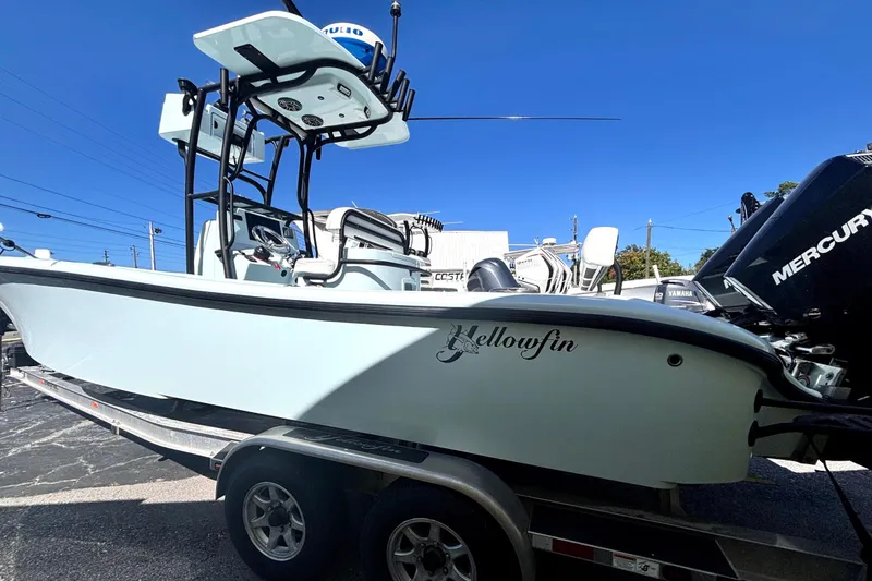 Slide: The Image of 2021 Yellowfin 26 Hybrid boat on trailer, featuring Mercury engines, under clear blue sky. - 14