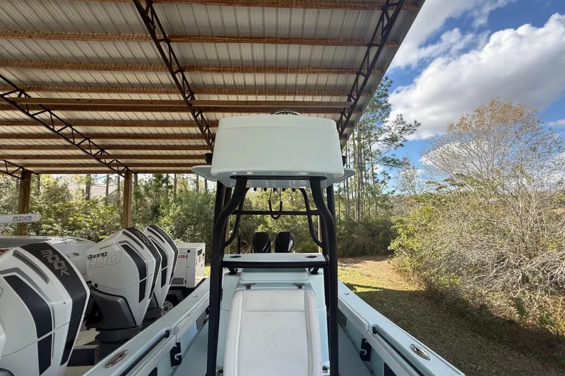 Slide: The Image of 2021 Yellowfin 26 Hybrid boat under a metal canopy with multiple outboard engines. - 20