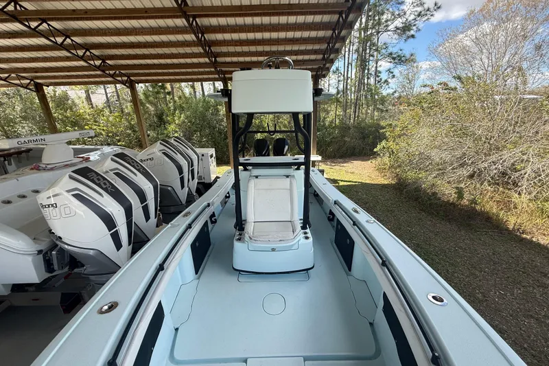 Slide: The Image of 2021 Yellowfin 26 Hybrid boat with powerful outboard engines, under a covered structure. - 23