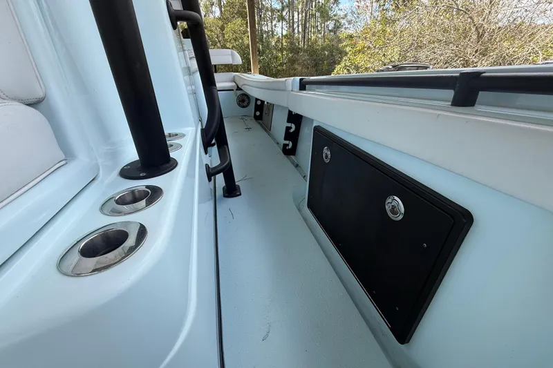 Slide: The Image of 2021 Yellowfin 26 Hybrid boat interior with rod holders and storage compartment. - 27