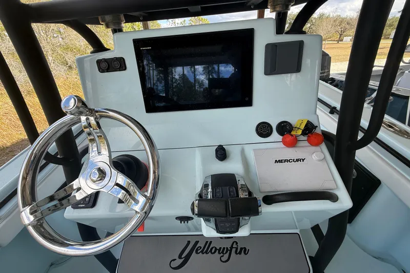 Slide: The Image of 2021 Yellowfin 26 Hybrid boat dashboard with steering wheel and Mercury controls. - 35
