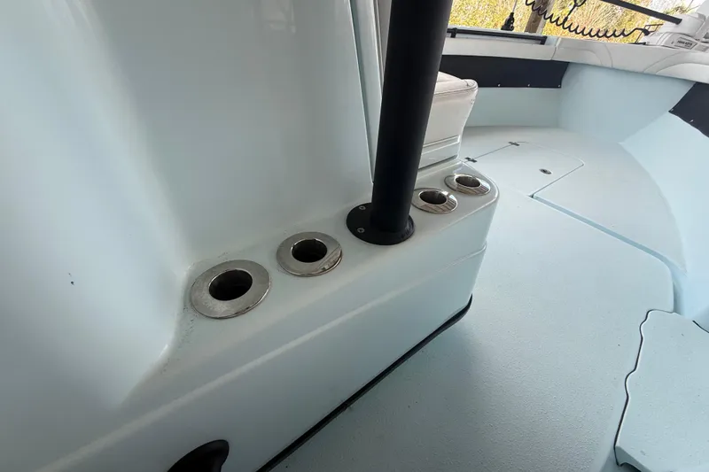 Slide: The Image of 2021 Yellowfin 26 Hybrid boat interior with rod holders and seating area. - 36