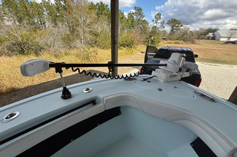Slide: The Image of 2021 Yellowfin 26 Hybrid boat with trolling motor, parked near a truck in a rural setting. - 38