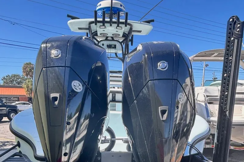 Slide: The Image of 2021 Yellowfin 26 Hybrid boat with dual outboard engines, parked outdoors. - 4