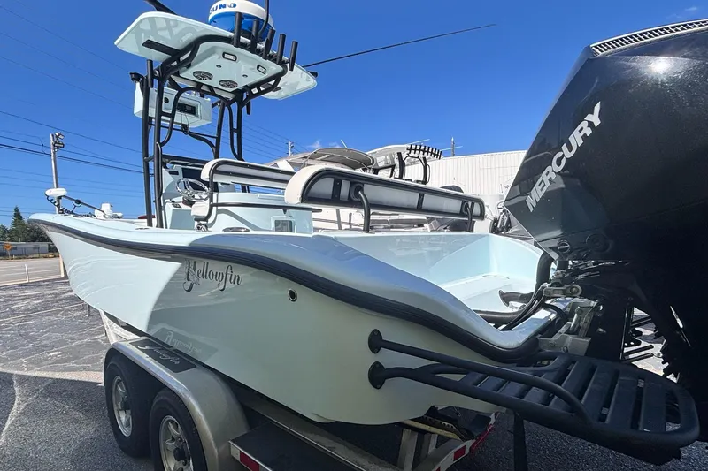 Slide: The Image of 2021 Yellowfin 26 Hybrid boat with Mercury engine on trailer, outdoor setting. - 5