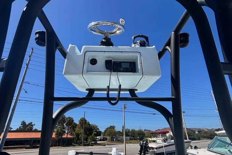 Slide: The Image of 2021 Yellowfin 26 Hybrid boat console with steering wheel and controls, under clear blue sky. - 6