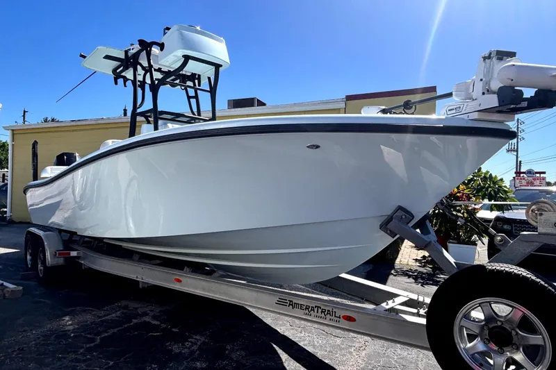 Slide: The Image of 2021 Yellowfin 26 Hybrid boat on trailer under clear blue sky. - 8