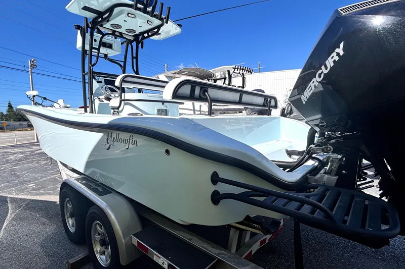 Slide: The Image of 2021 Yellowfin 26 Hybrid boat on trailer with Mercury engine, parked outdoors. - 9