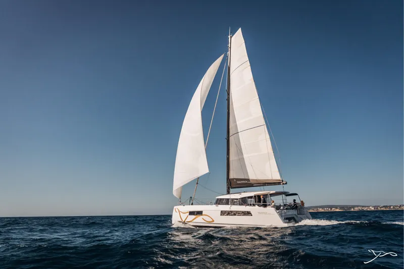 Slide: The Image of 2025 Nautitech 44 Open catamaran sailing on open sea under clear blue sky. - 3