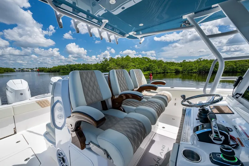 Slide: The Image of 2025 Invincible 37 Catamaran cockpit with luxurious seating and modern controls, set against a scenic waterway. - 11